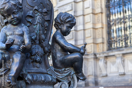 Bronze floor lamps are decorated with putti figures that represent various crafts in front of the A. L. Stieglitz Academy in St. Petersburg, Russia