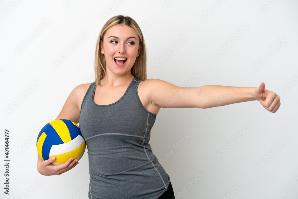 Young caucasian woman playing volleyball isolated on white background giving a thumbs up gesture