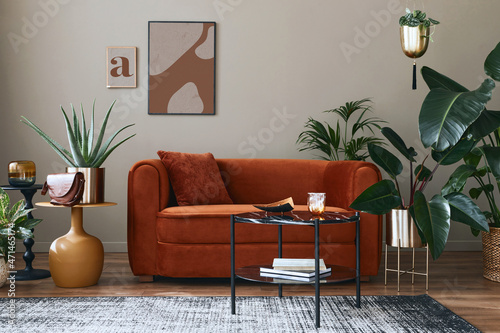 Domestic interior of living room with design sofa, mock up poster frames, a lot of plants, coffee table, room screen and elegant personal accessoreis in modern home decor. Template. photo