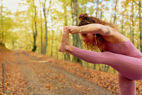 woman with closed eyes practicing yoga poses in the forest. meditation, mind and body. healthy life style.