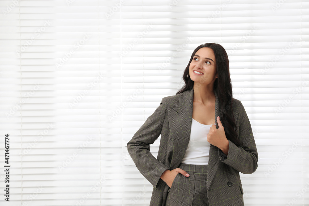 Beautiful woman in formal suit near window, space for text. Business attire Beautiful woman in formal suit near window, space for text. Business attire