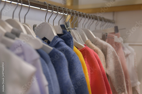 Blouses and sweaters hang on a hanger in the store