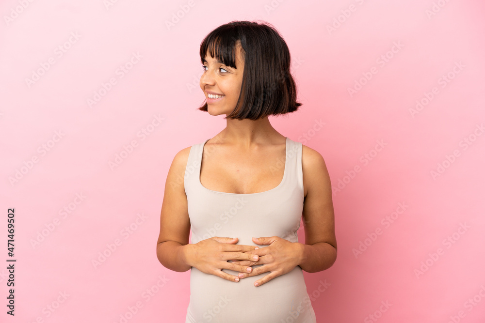 Young pregnant woman over isolated pink background looking side Young pregnant woman over isolated pink background looking side