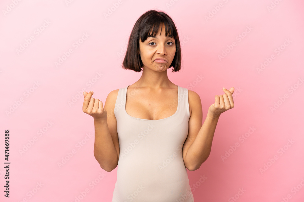 Young pregnant woman over isolated pink background making money gesture but is ruined Young pregnant woman over isolated pink background making money gesture but is ruined