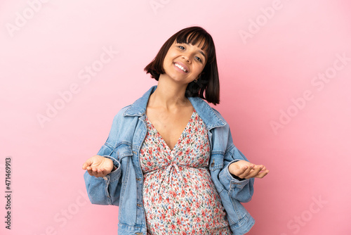 Young pregnant woman over isolated pink background presenting and inviting to come with hand