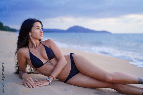 Vacation on the seashore.Young beautiful woman with long brunette hair on the sand beach.