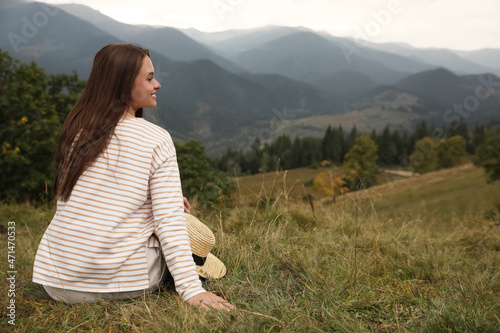 Young woman enjoying beautiful mountain landscape. Space for text