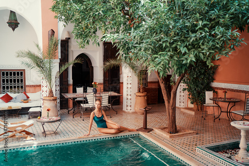 Retreat and vacation. Beautiful young woman relaxing in spa private swimming pool in beautiful moroccan backyard. © luengo_ua