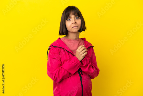 Young pregnant woman over isolated yellow background laughing © luismolinero