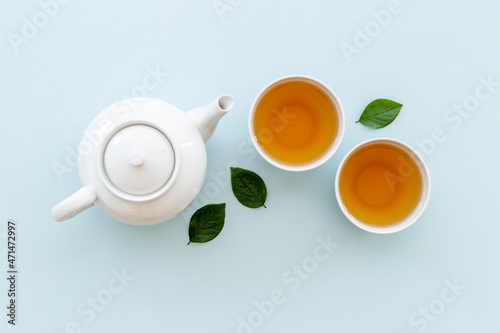 Asian food and drink set white teapot and black tea in two cups