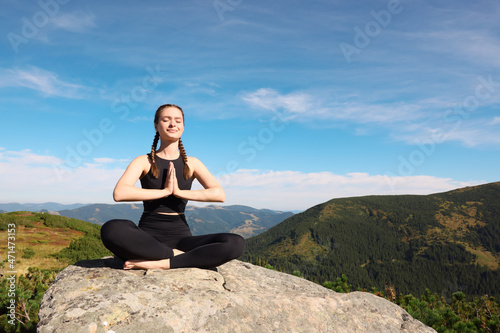 Young woman practicing outdoor yoga in mountains  space for text. Fitness lifestyle