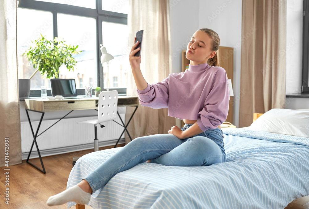 people, children and technology concept - happy smiling teenage girl with smartphone taking selfie and making duck face at home people, children and technology concept - happy smiling teenage girl with smartphone taking selfie and making duck face at home