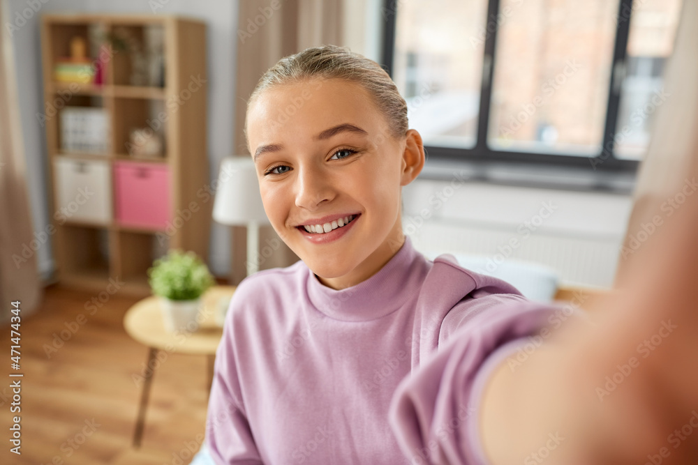 people, children and technology concept - happy smiling girl taking selfie at home people, children and technology concept - happy smiling girl taking selfie at home