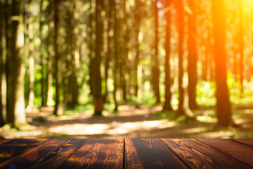 Forest wooden table background. Summer sunny meadow with green grass, forest trees background and rustic wooden surface for goods, products, food
