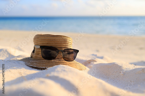 Holiday and Relaxation - Sunglasses and a hat at the Beach.