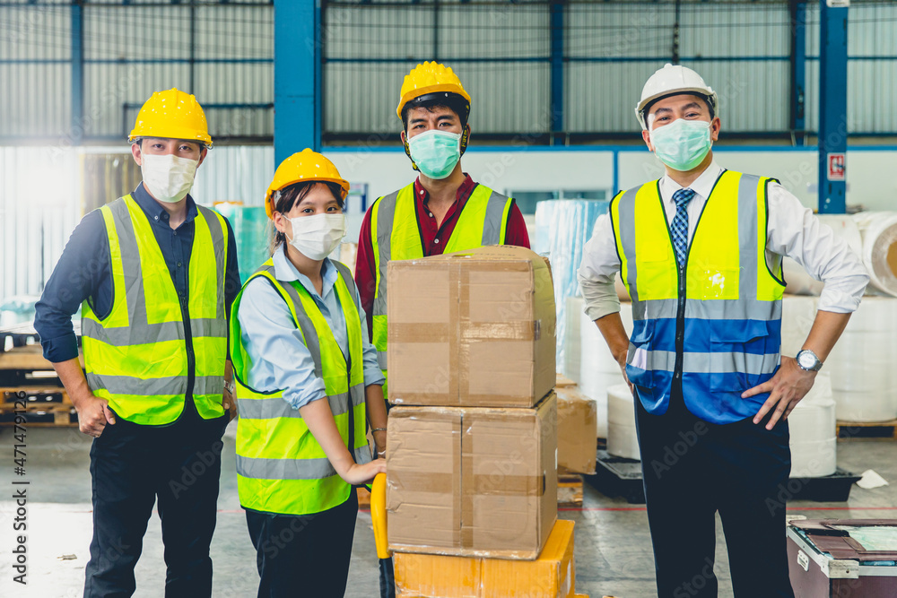 Group of team Asian worker wear face mask standing together in store warehouse Group of team Asian worker wear face mask standing together in store warehouse