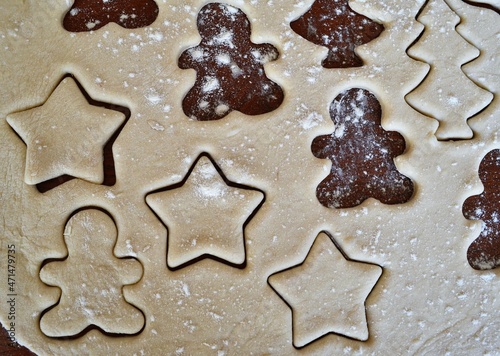 Christmas cookie dough stretched and cut with molds in the shape of a gingerbread man and stars