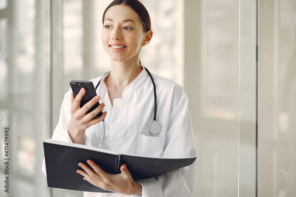 Woman doctor in a white uniforn standing in a hall