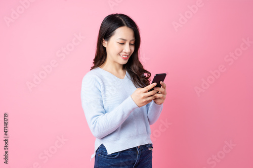 Portrait of a beautiful young Asian girl, isolated on pink background