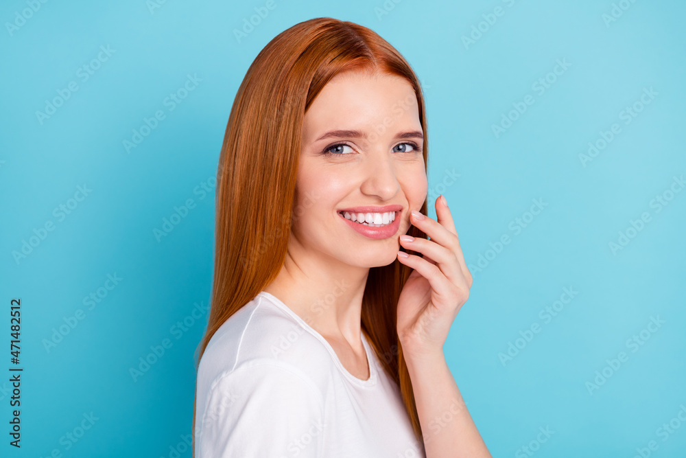 Profile photo of charming positive orange hair girl hand fingers touch face isolated on blue color background Profile photo of charming positive orange hair girl hand fingers touch face isolated on blue color background