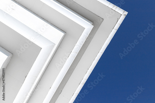 White concrete ceiling corners under clear blue sky