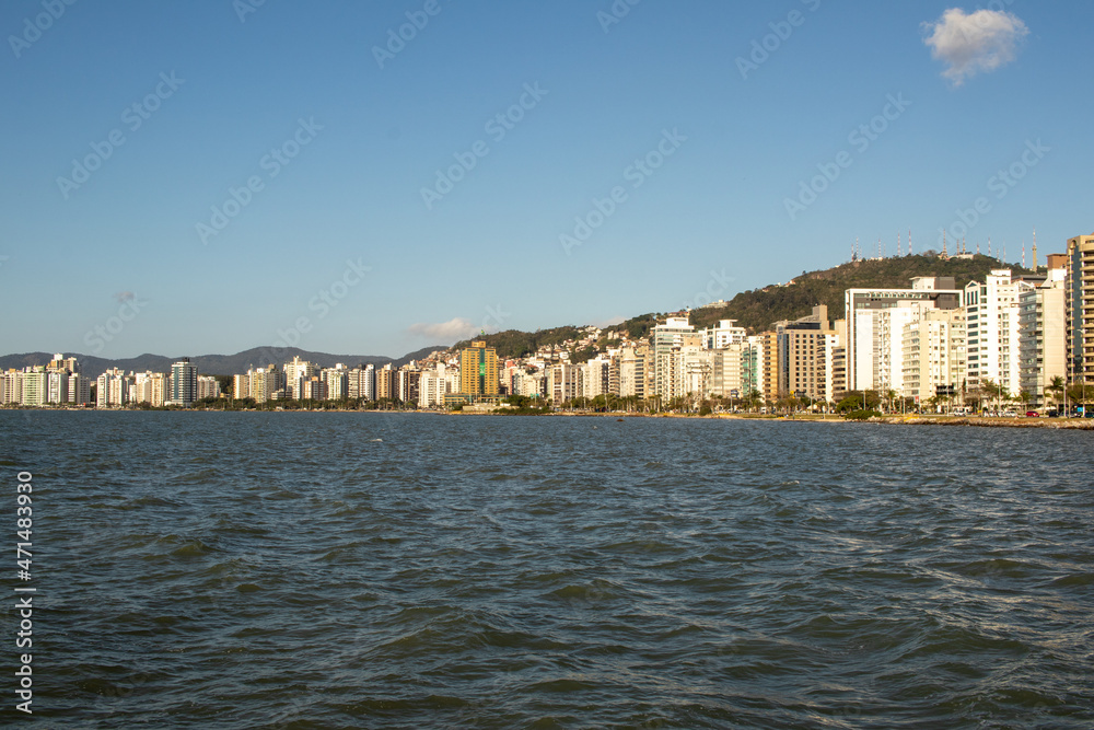 sea water, blue sky and beautiful view of the city's waterfront buildings
