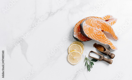 two raw salmon steaks on a white marble surface. the concept of a healthy dinner for two from salmon steaks. fresh salmon steaks.