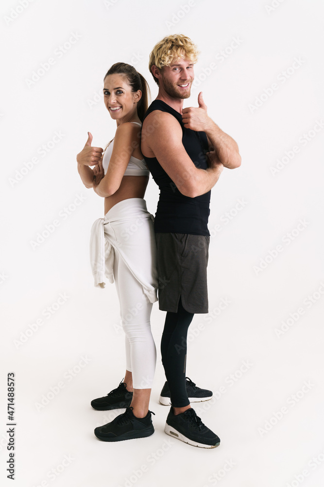 European couple in sportswear smiling and showing thumbs up