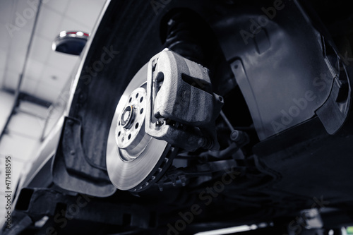 Closeup of steel brake disc in car service. Concept for replacing wheel pads in garage