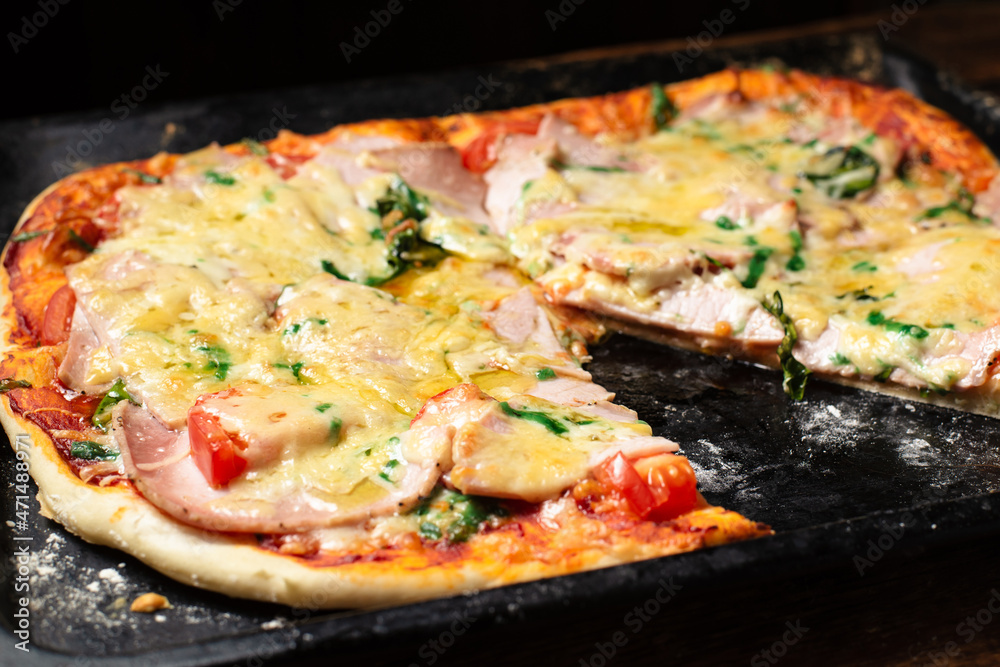 Homemade pizza on a baking sheet. Pizza with sausage, tomatoes, cheese. Homemade pizza on a baking sheet. Pizza with sausage, tomatoes, cheese.