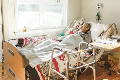 Sick, elderly senior woman in a hospital bed