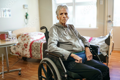 Sick, elderly senior woman in a hospital room with wheel chair