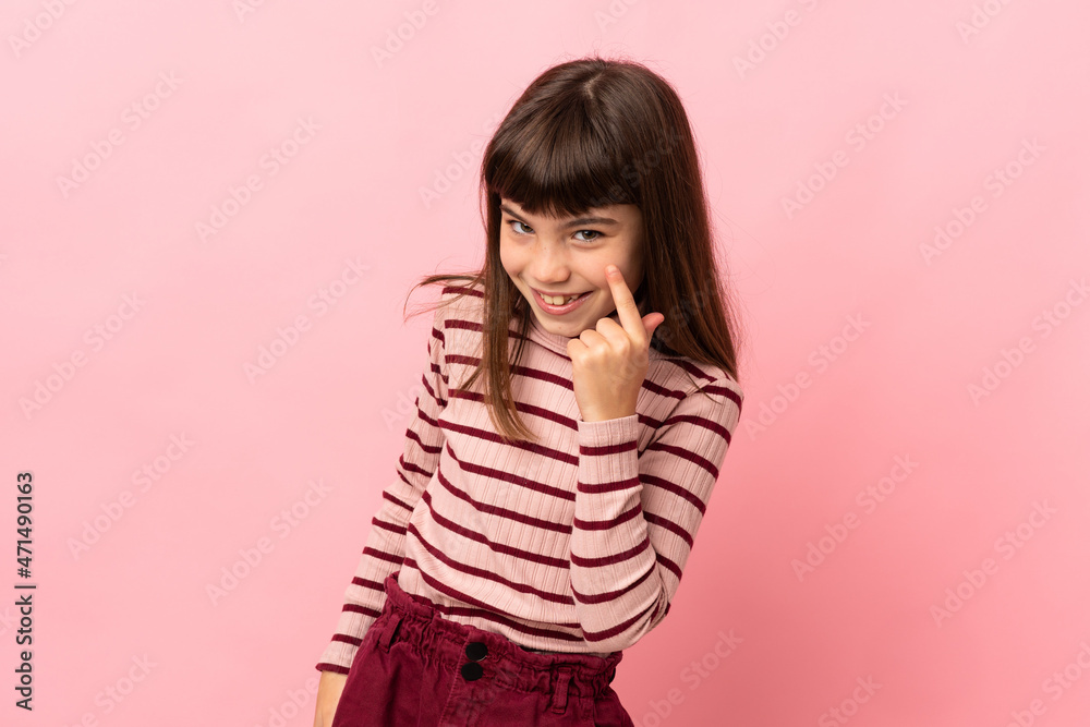 Little girl isolated on pink background showing something Little girl isolated on pink background showing something