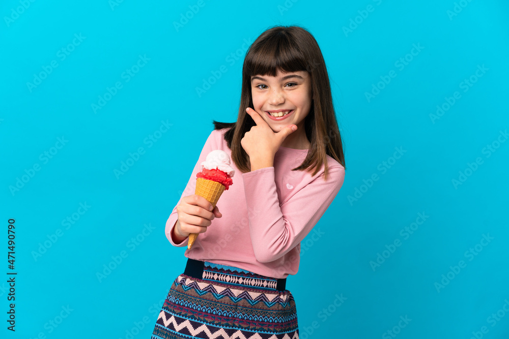 Little girl with a cornet ice cream isolated on blue background happy and smiling Little girl with a cornet ice cream isolated on blue background happy and smiling