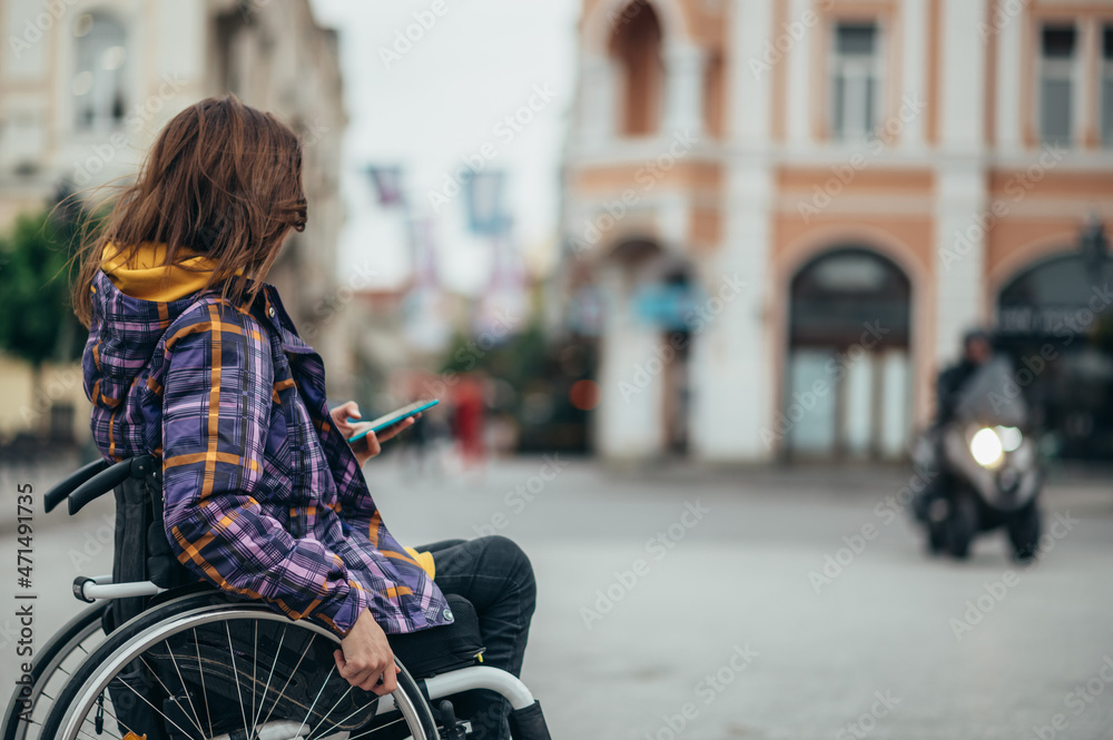 Woman with disability using a smartphone while out in the city Woman with disability using a smartphone while out in the city