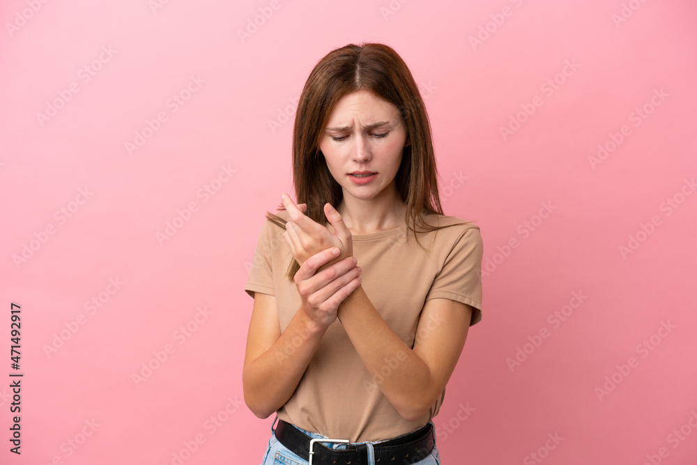 Young English woman isolated on pink background suffering from pain in hands Young English woman isolated on pink background suffering from pain in hands