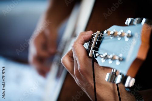 Hand playing on a guitar.