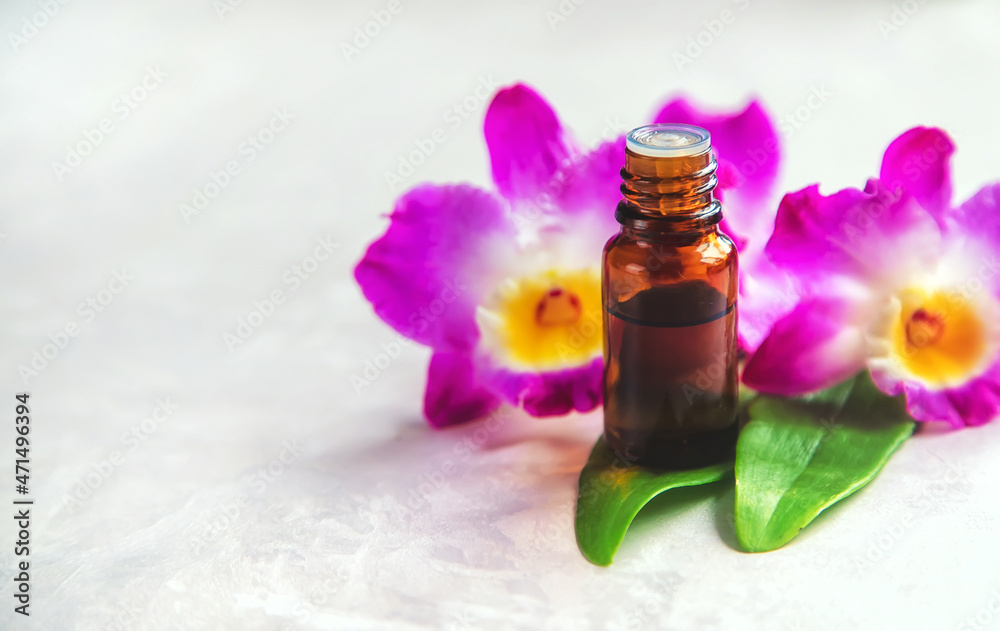 Orchid essential oil in a small bottle. Selective focus. Orchid essential oil in a small bottle. Selective focus.
