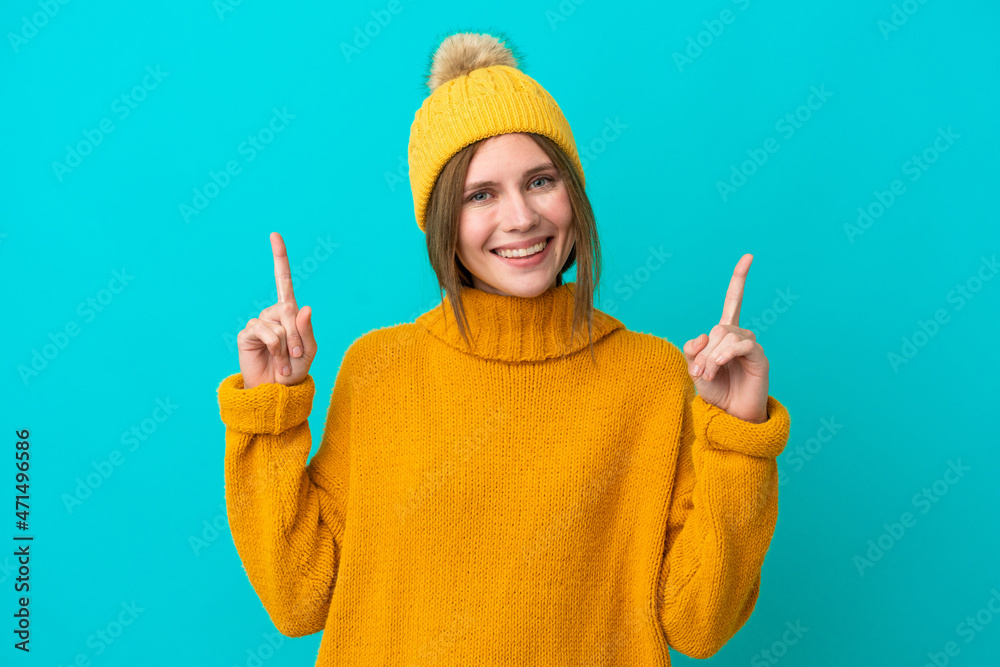 Young English woman wearing winter jacket isolated on blue background pointing up a great idea
