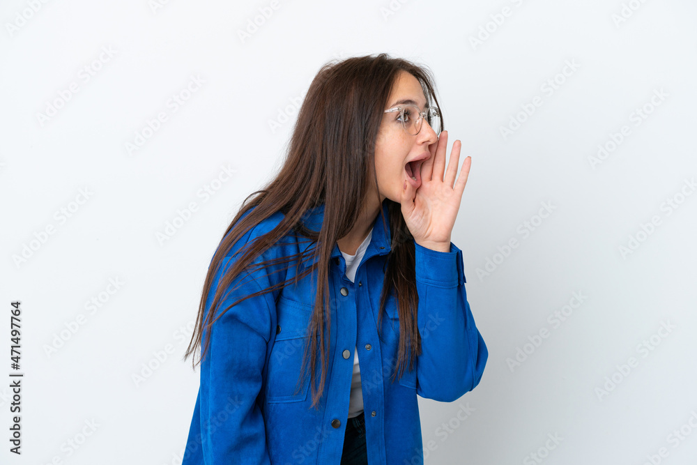 Young Ukrainian woman isolated on white background shouting with mouth wide open to the side Young Ukrainian woman isolated on white background shouting with mouth wide open to the side