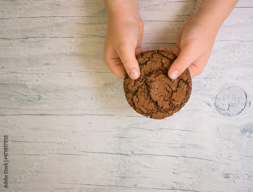  child's hands hold chocolate chip cookies