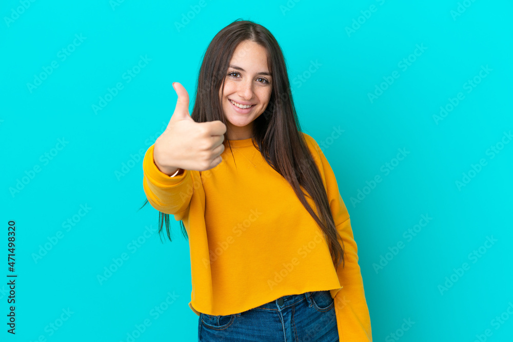 Young Ukrainian woman isolated on blue background with thumbs up because something good has happened