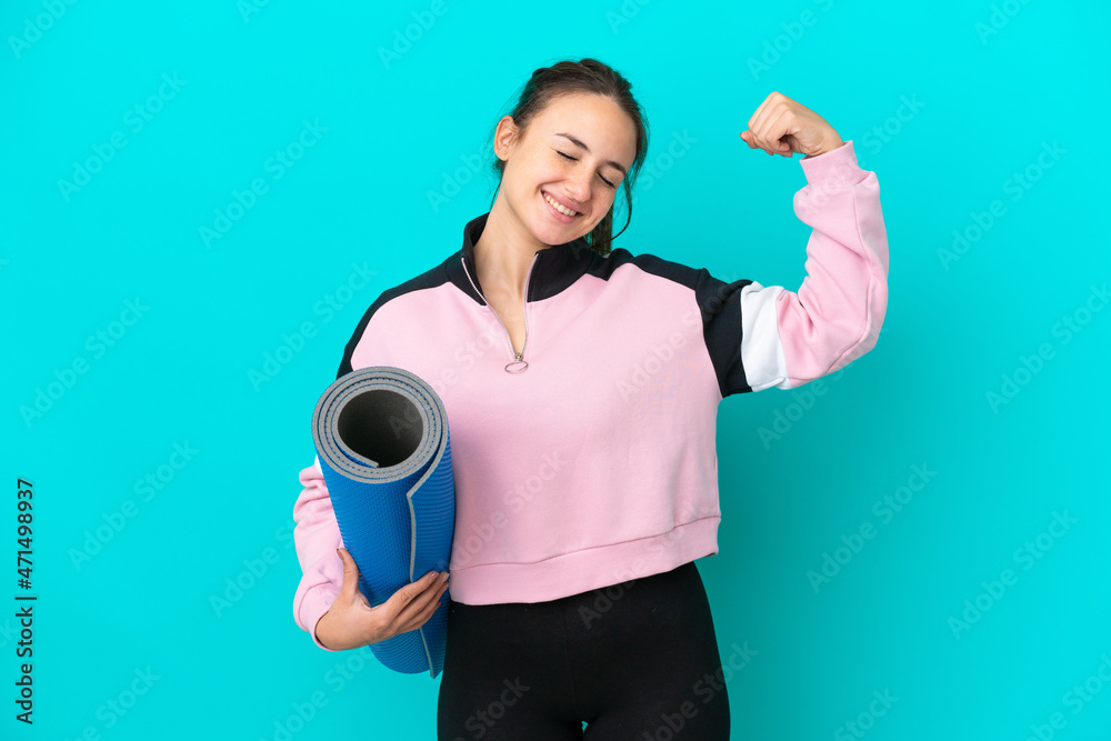 Sport Ukrainian woman going to yoga classes while holding a mat doing strong gesture Sport Ukrainian woman going to yoga classes while holding a mat doing strong gesture