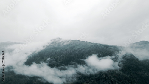 Flying in the clouds to the mountain during light rain