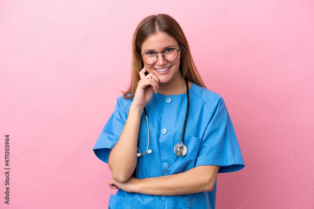 Young surgeon doctor woman isolated on pink background with glasses and smiling Young surgeon doctor woman isolated on pink background with glasses and smiling
