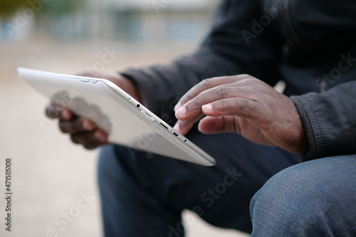 African american man uses tablet computer. Black mans hands holds a tablet pc