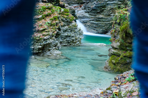 A hiker is looking at the clear waters of the Rui stream, Mel, Belluno, Italy photo