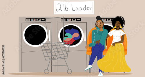 Lesbian couple waiting for clothes to finish in the laundromat 
