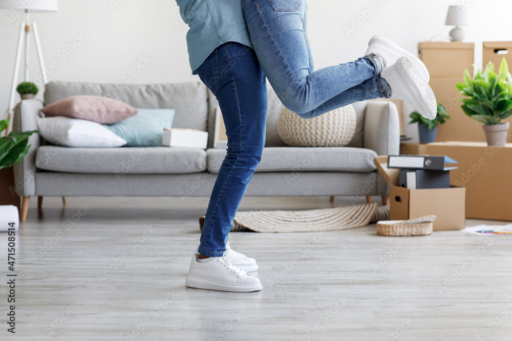 Cropped young black male hugs and lifts woman in own apartment with cardboard boxes Cropped young black male hugs and lifts woman in own apartment with cardboard boxes
