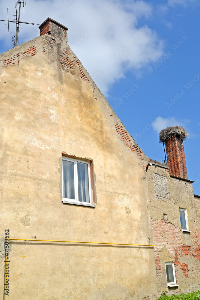 A fragment of an old German-built building with a stork nest on a chimney. Polessk, Kaliningrad region